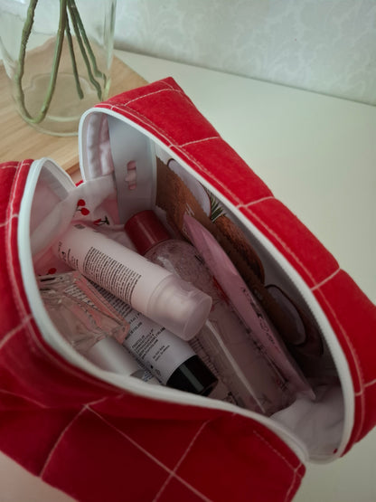 Punaruudullinen tilava meikkipussi, suomalaista designia.
